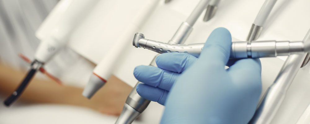 Metal instruments for the treatment of teeth. Dental clinic. Hands in a blue gloves